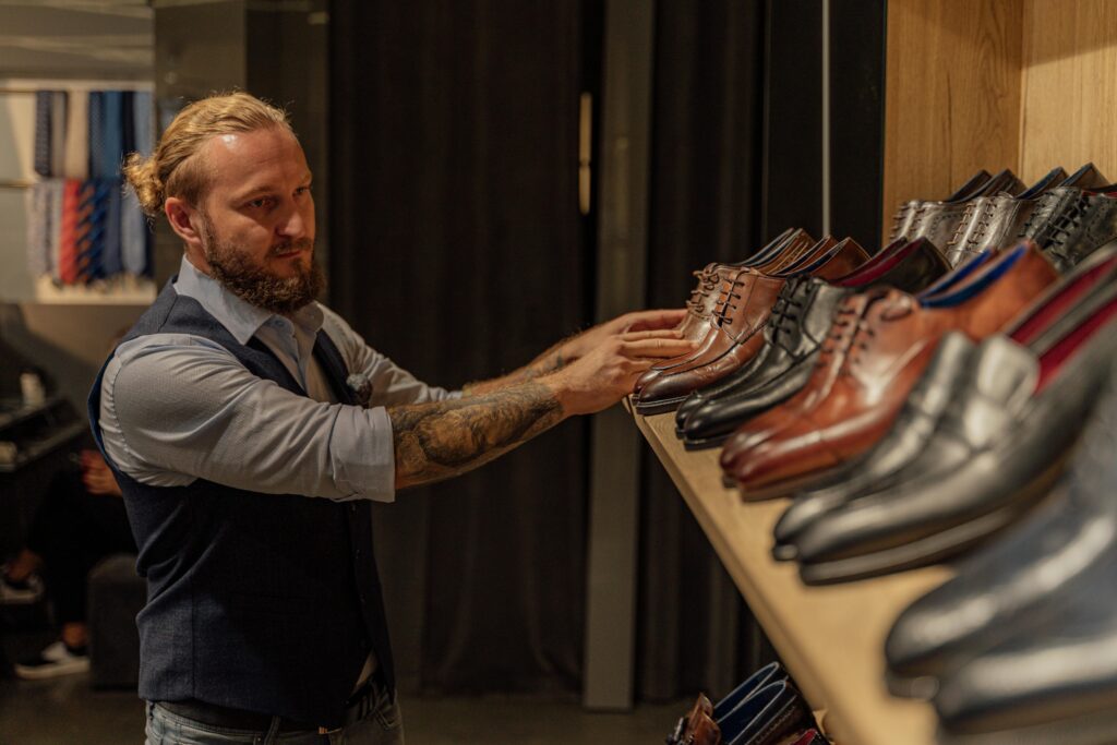 Man in Gray Dress Shirt Holding Brown Leather Shoes